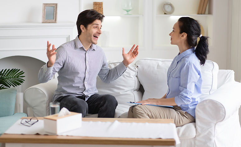 Man suffering from euphoria talks with psychologist in therapy session