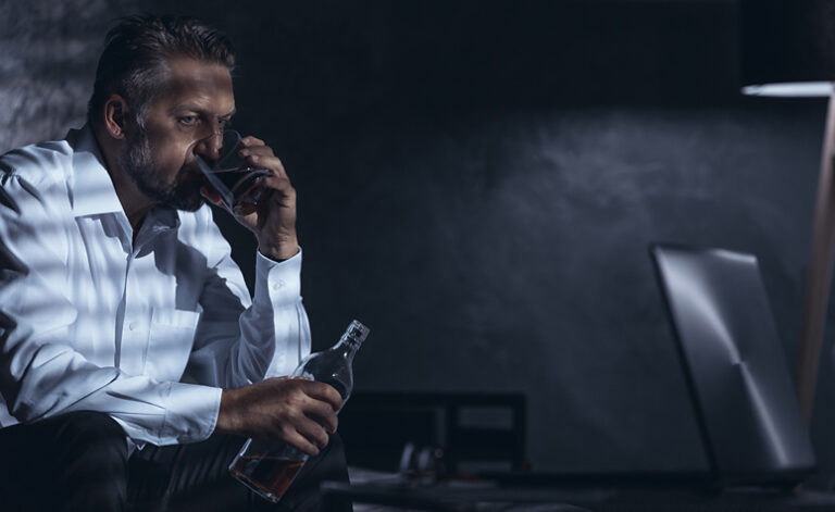 Stressed businessman drinking trying to cope with his depression