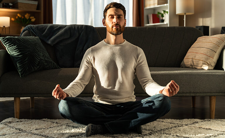 Man meditating at home as part of his recovery from addiction journey