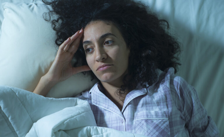 Woman laid in bed feeling sad and depressed due to her sexual relationship issues