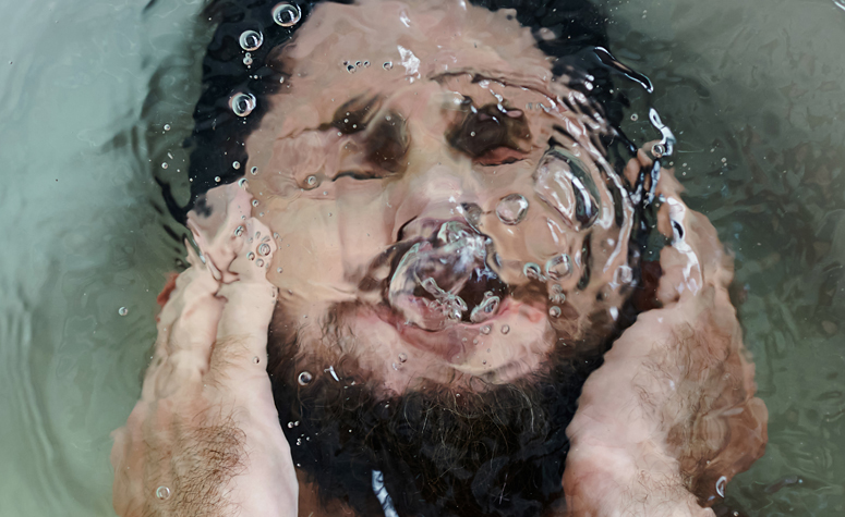 Man laid in the bath struggling with his symptoms of PTSD